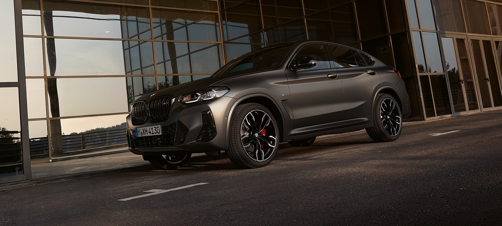 BMW X4 M40i G02 LCI Renovación 2021 Vista de tres cuartos del frontal delante de fachada de cristal